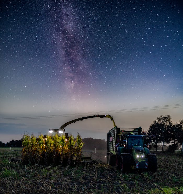 A farm harvester working under the Milky Way in Stemwede, Germany, capturing agriculture and astronomy.