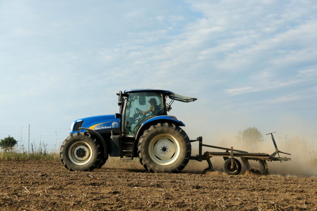 Blue tractor in action plowing a field in Bissendorf, capturing the essence of countryside agriculture.