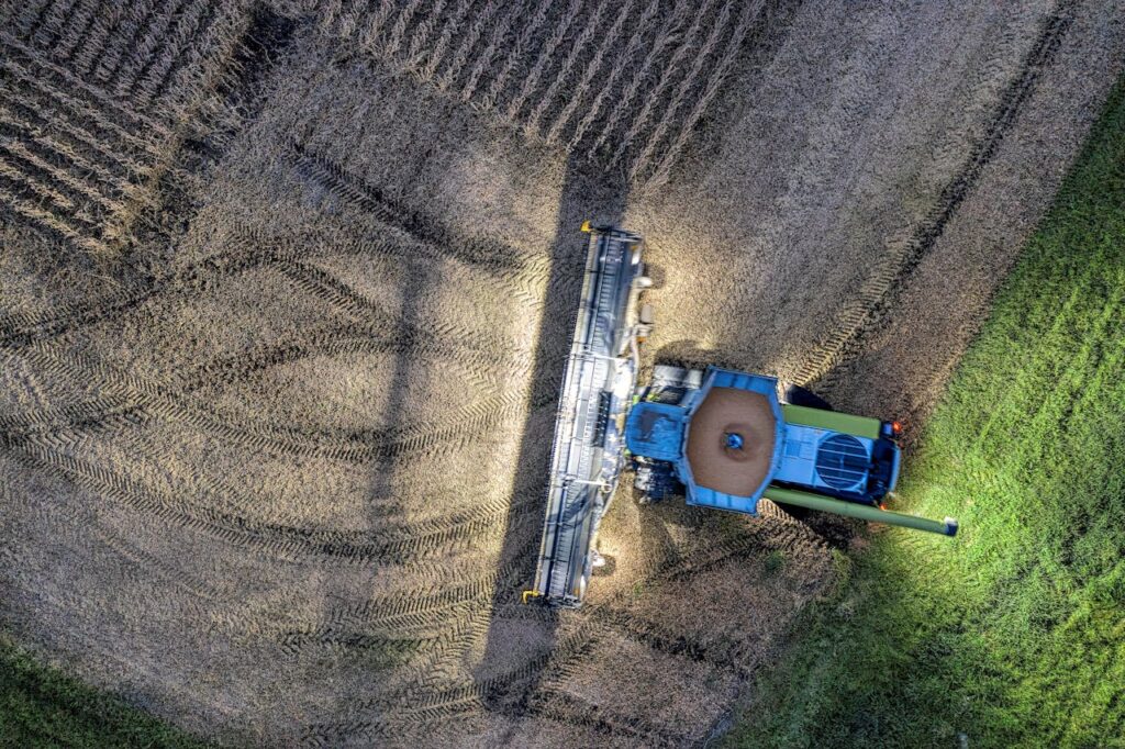 A drone's eye view of a tractor harvesting crops in a Minnesota field.